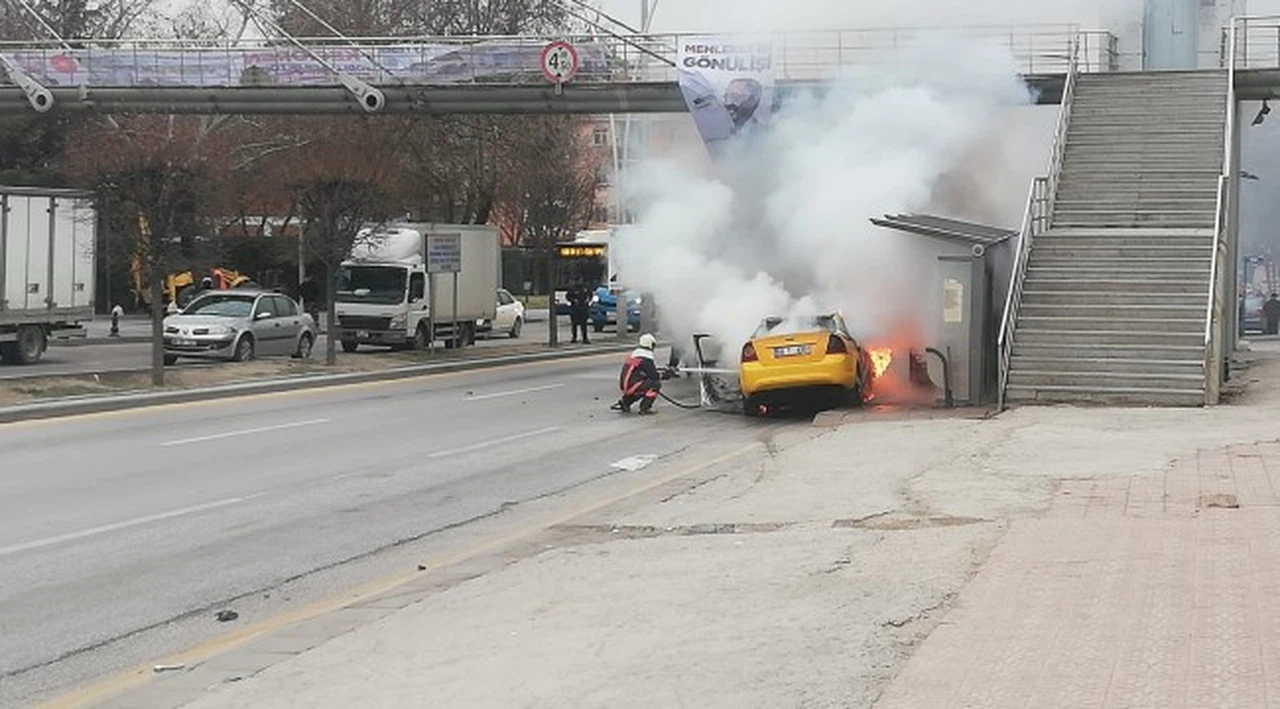 Otomobil ve otobüs durağına çarpan ticari taksi alev aldı