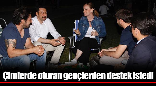 Çimlerde oturan gençlerden destek istedi