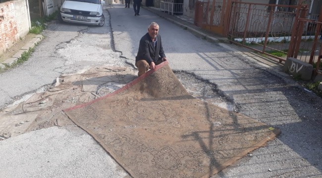 Asfalt bekleyen bozuk yola halı serdiler