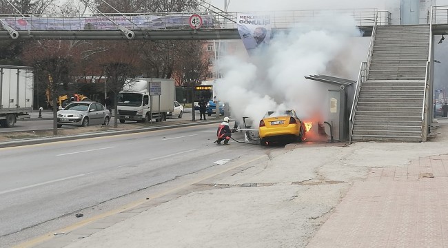 Otomobil ve otobüs durağına çarpan ticari taksi alev aldı