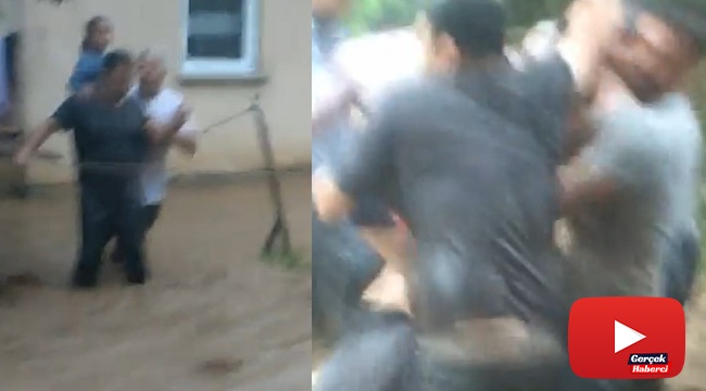 Evden yola ip çekerek dere gibi akan suyun içerisinden geçtiler
