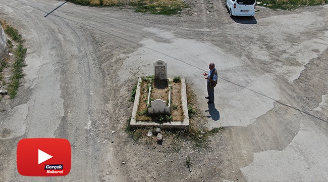 Yol ortasında kalan mezar görenleri şaşırtıyor