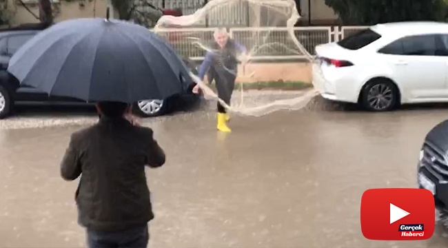 Göle dönen yollarda ağ atıp balık tutmaya çalıştı
