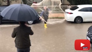Göle dönen yollarda ağ atıp balık tutmaya çalıştı