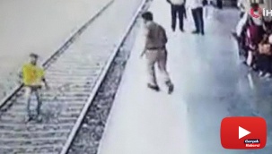 Polis raylara atlayan genci son anda kurtardı